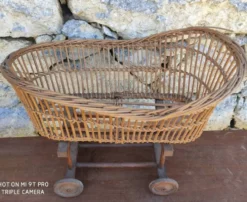 Ancien berceau en rotin à roulettes