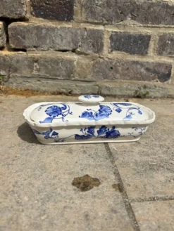 Beurrier ancien en faïence, décor fleuri bleu et blanc