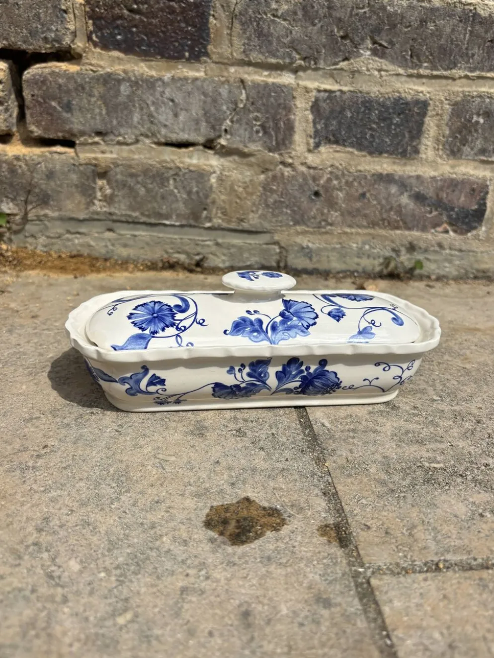 Beurrier ancien en faïence, décor fleuri bleu et blanc