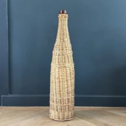 Bouteille en verre ambré dans son panier à poignée en osier
