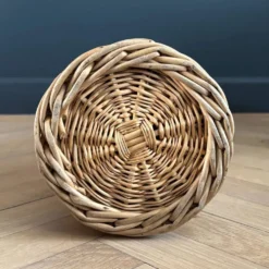 Bouteille en verre ambré dans son panier à poignée en osier