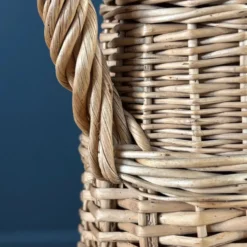 Bouteille en verre ambré dans son panier à poignée en osier