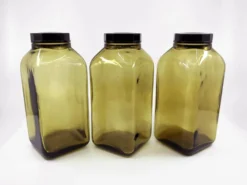 3 bouteilles de pharmacie en verre ambré moulé • bouchons bakélite • 1950