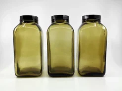 3 bouteilles de pharmacie en verre ambré moulé • bouchons bakélite • 1950
