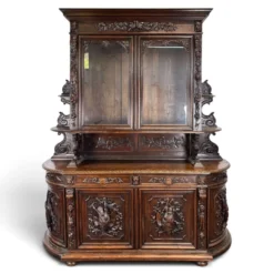 Buffet deux corps de chasse de style Henri II en chêne sculpté vitré