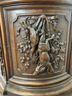 Buffet deux corps de chasse de style Henri II en chêne sculpté vitré