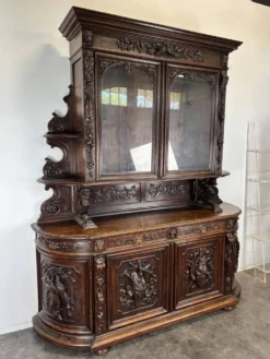 Buffet deux corps de chasse de style Henri II en chêne sculpté vitré