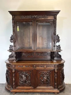 Buffet deux corps de chasse de style Henri II en chêne sculpté vitré
