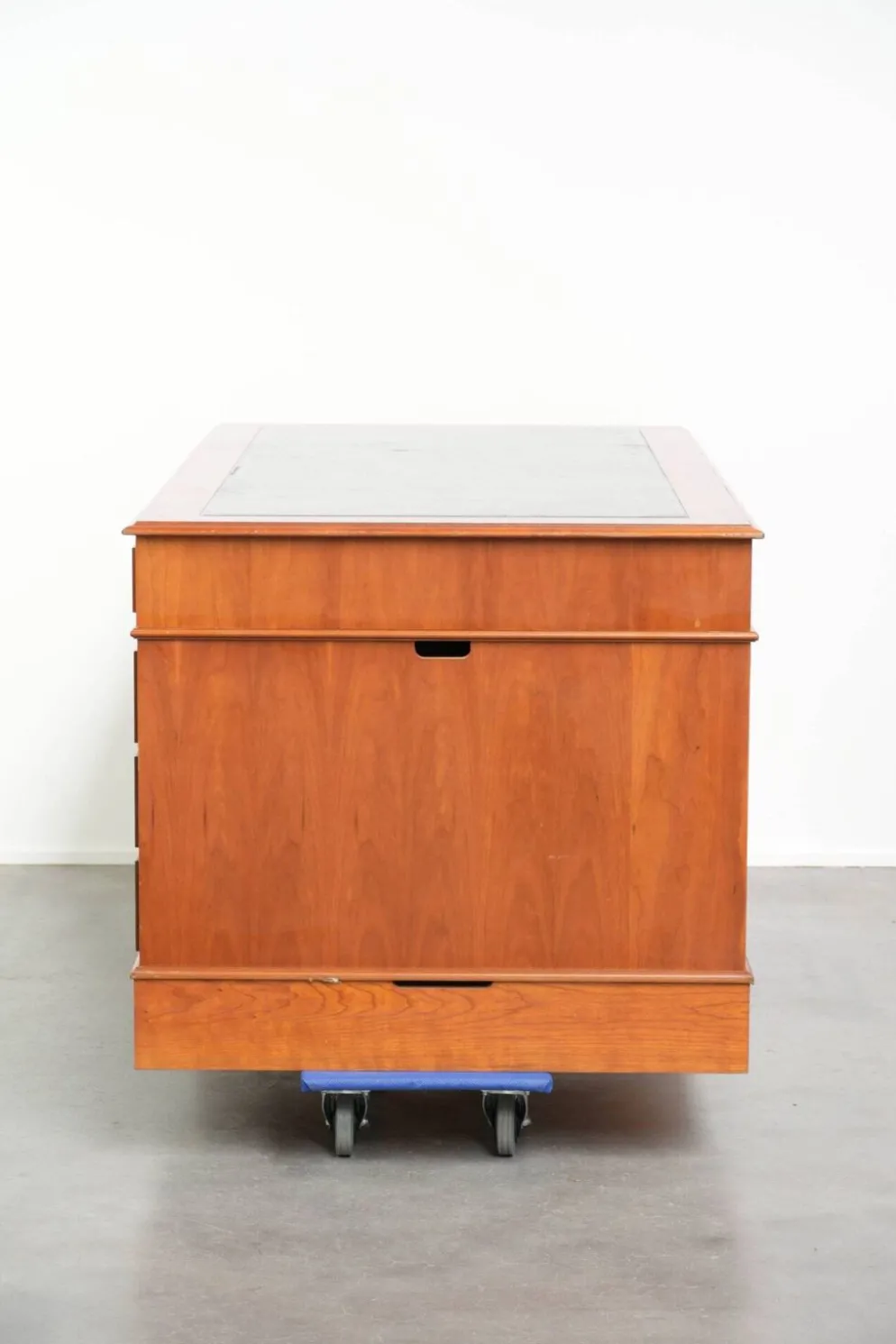 Bureau en bois classique de style anglais avec 4 tiroirs et un dessus en cuir bleu.