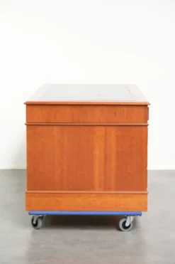 Bureau en bois classique de style anglais avec 4 tiroirs et un dessus en cuir bleu.