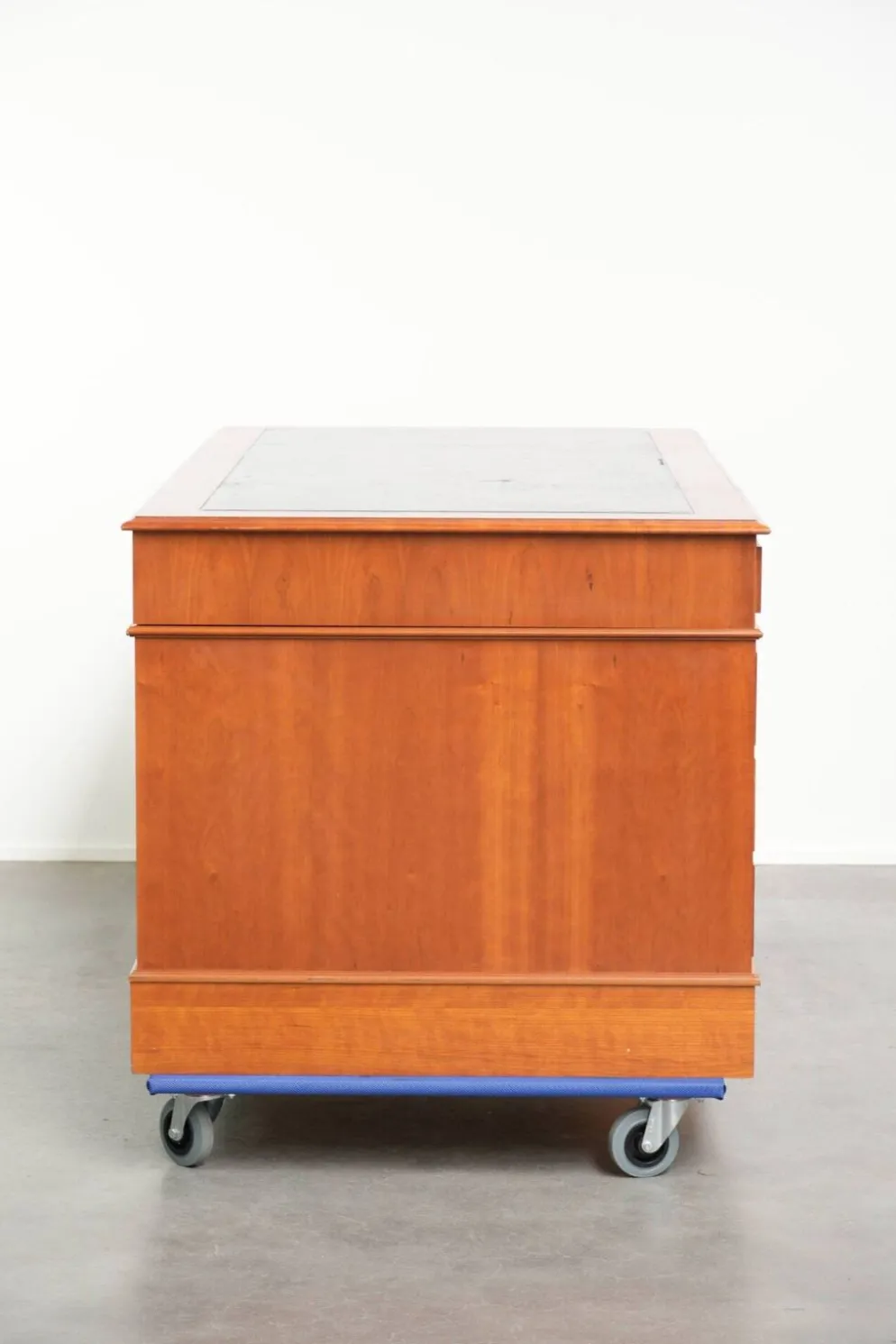 Bureau en bois classique de style anglais avec 4 tiroirs et un dessus en cuir bleu.