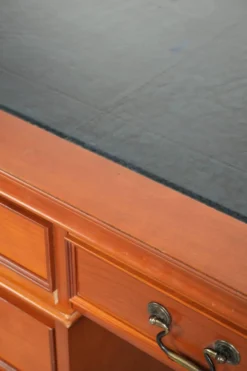 Bureau en bois classique de style anglais avec 4 tiroirs et un dessus en cuir bleu.