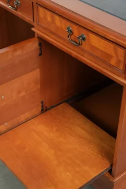 Bureau en bois classique de style anglais avec 4 tiroirs et un dessus en cuir bleu.