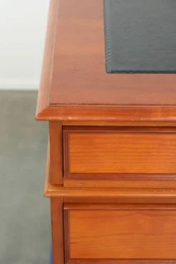 Bureau en bois classique de style anglais avec 4 tiroirs et un dessus en cuir bleu.