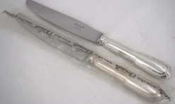 Christofle modèle Chinon, 10 couteaux de table, dont 9 intacts sous blisters scellés.