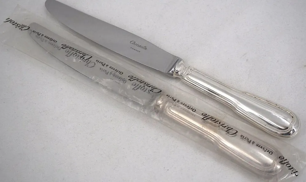 Christofle modèle Chinon, 10 couteaux de table, dont 9 intacts sous blisters scellés.