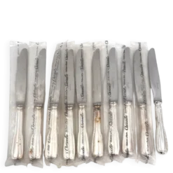 Christofle modèle Chinon, 10 couteaux de table, dont 9 intacts sous blisters scellés.