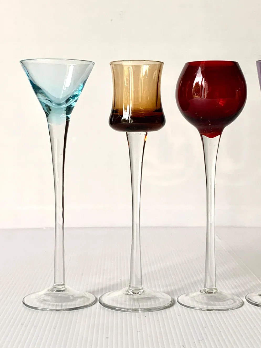 Cinq verres à liqueur colorés sur pied