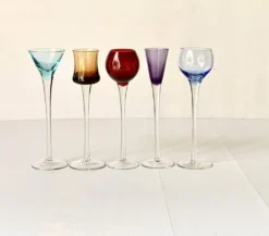 Cinq verres à liqueur colorés sur pied