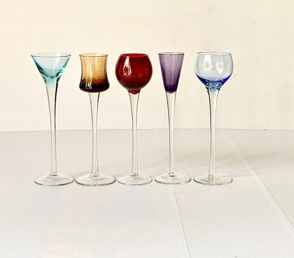 Cinq verres à liqueur colorés sur pied