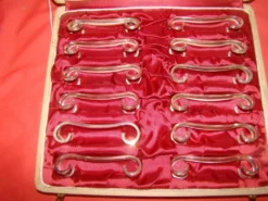 Coffret de 12 porte-couteau en métal argenté avec écrin, époque début 20 ème