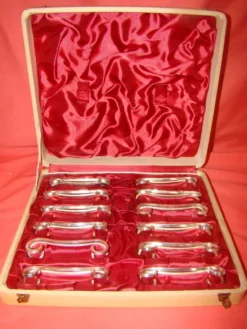 Coffret de 12 porte-couteau en métal argenté avec écrin, époque début 20 ème