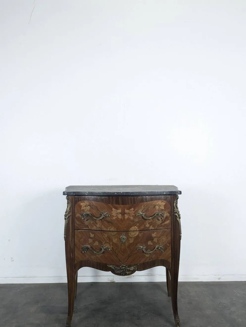Commode galbée de style Louis XV en marqueterie florale dessus marbre noir