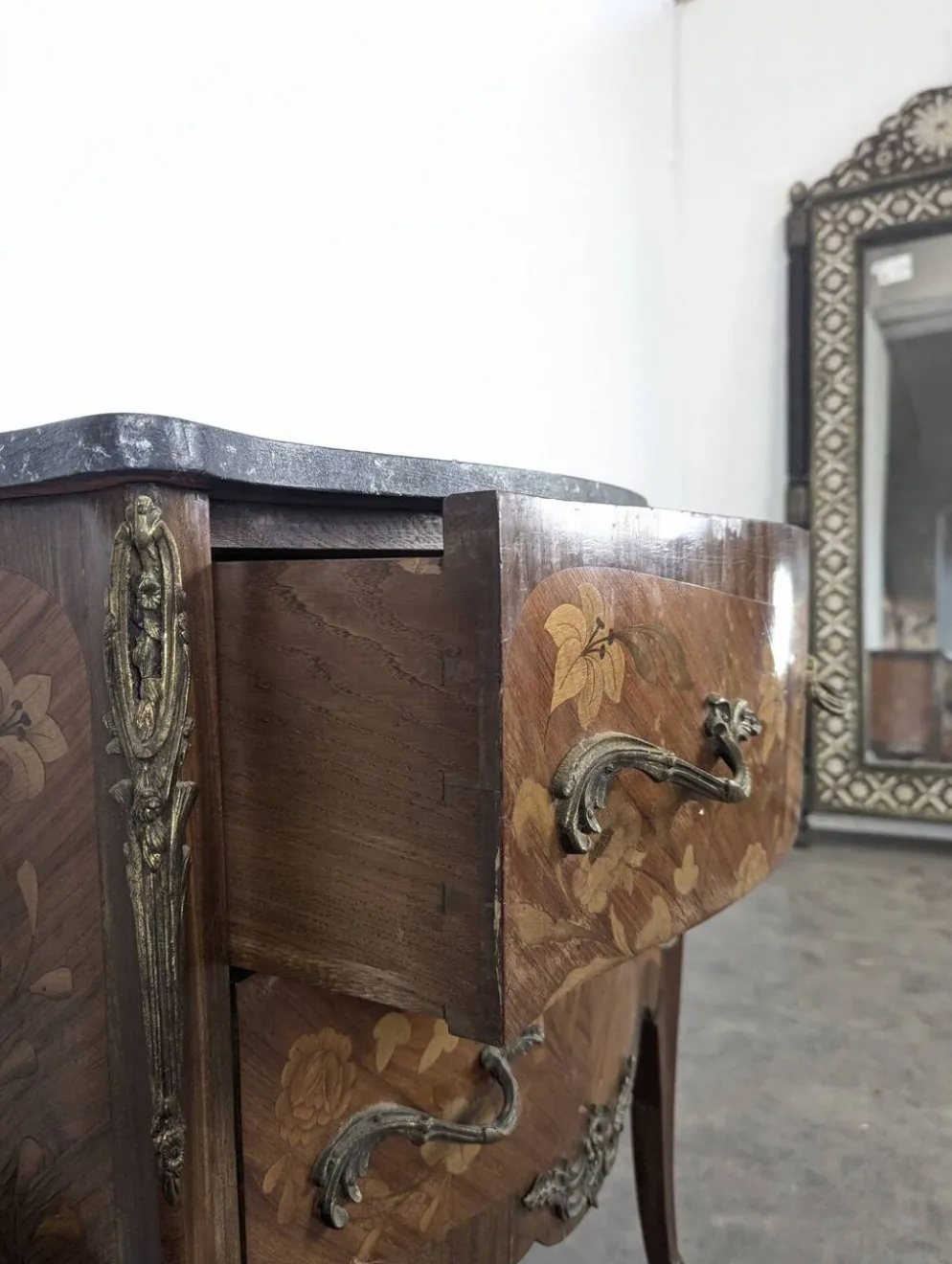 Commode galbée de style Louis XV en marqueterie florale dessus marbre noir