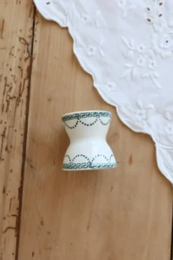 Coquetier diabolo ancien en terre de fer ivoire et motif vert