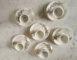 6 coquetiers fleuris avec leur coupelle début XXe en porcelaine