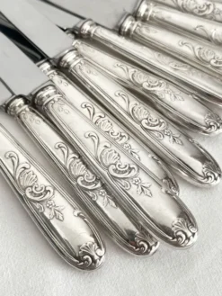 12 couteaux anciens en métal argenté décor acanthe coquille lame inox