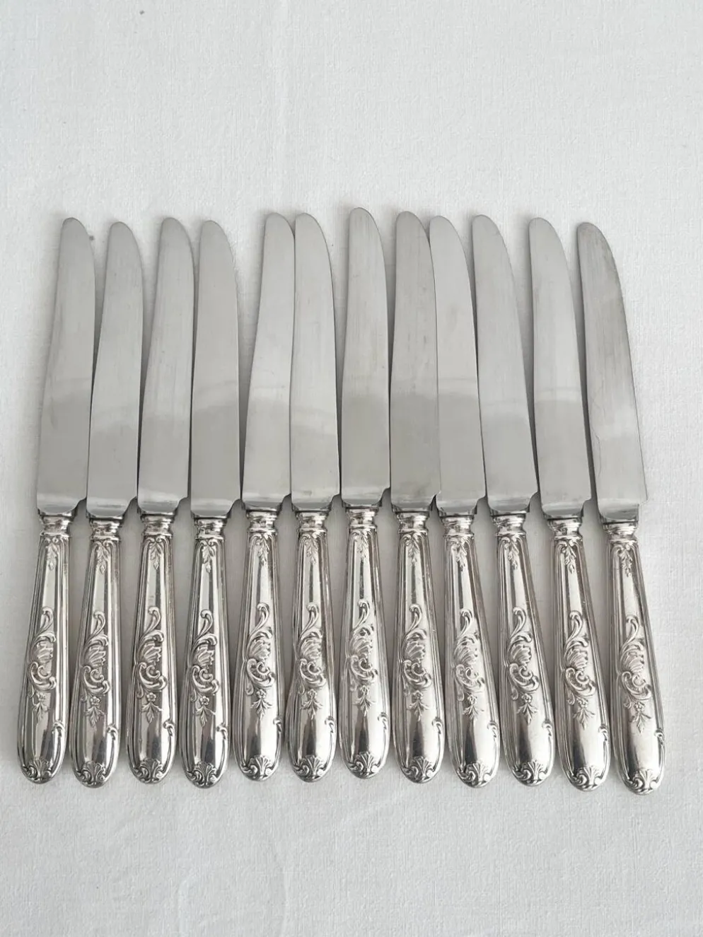 12 couteaux anciens en métal argenté décor acanthe coquille lame inox