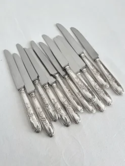 12 couteaux anciens en métal argenté décor acanthe coquille lame inox
