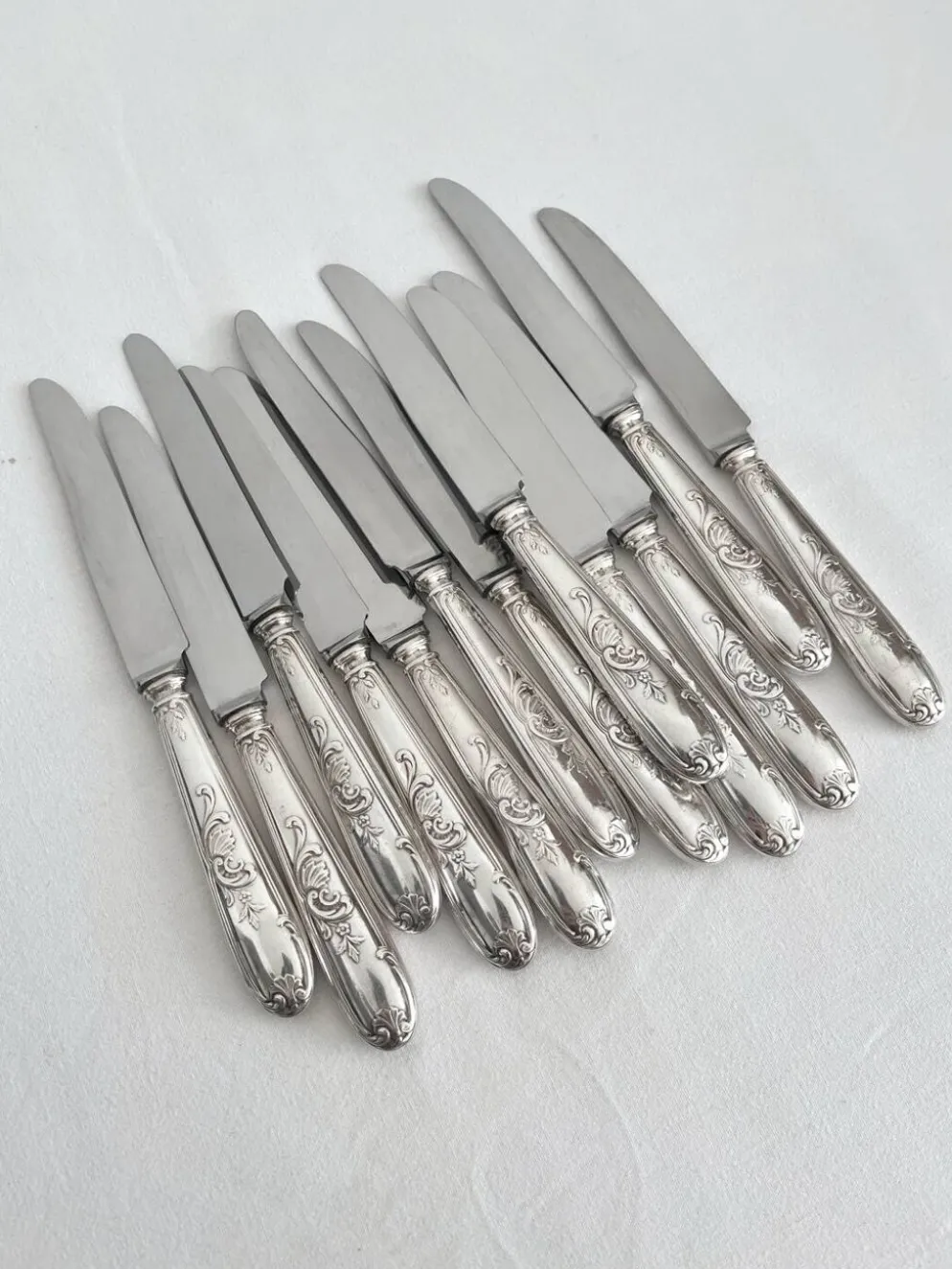 12 couteaux anciens en métal argenté décor acanthe coquille lame inox