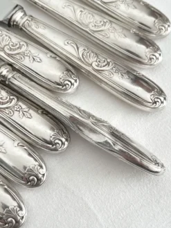 12 couteaux anciens en métal argenté décor acanthe coquille lame inox