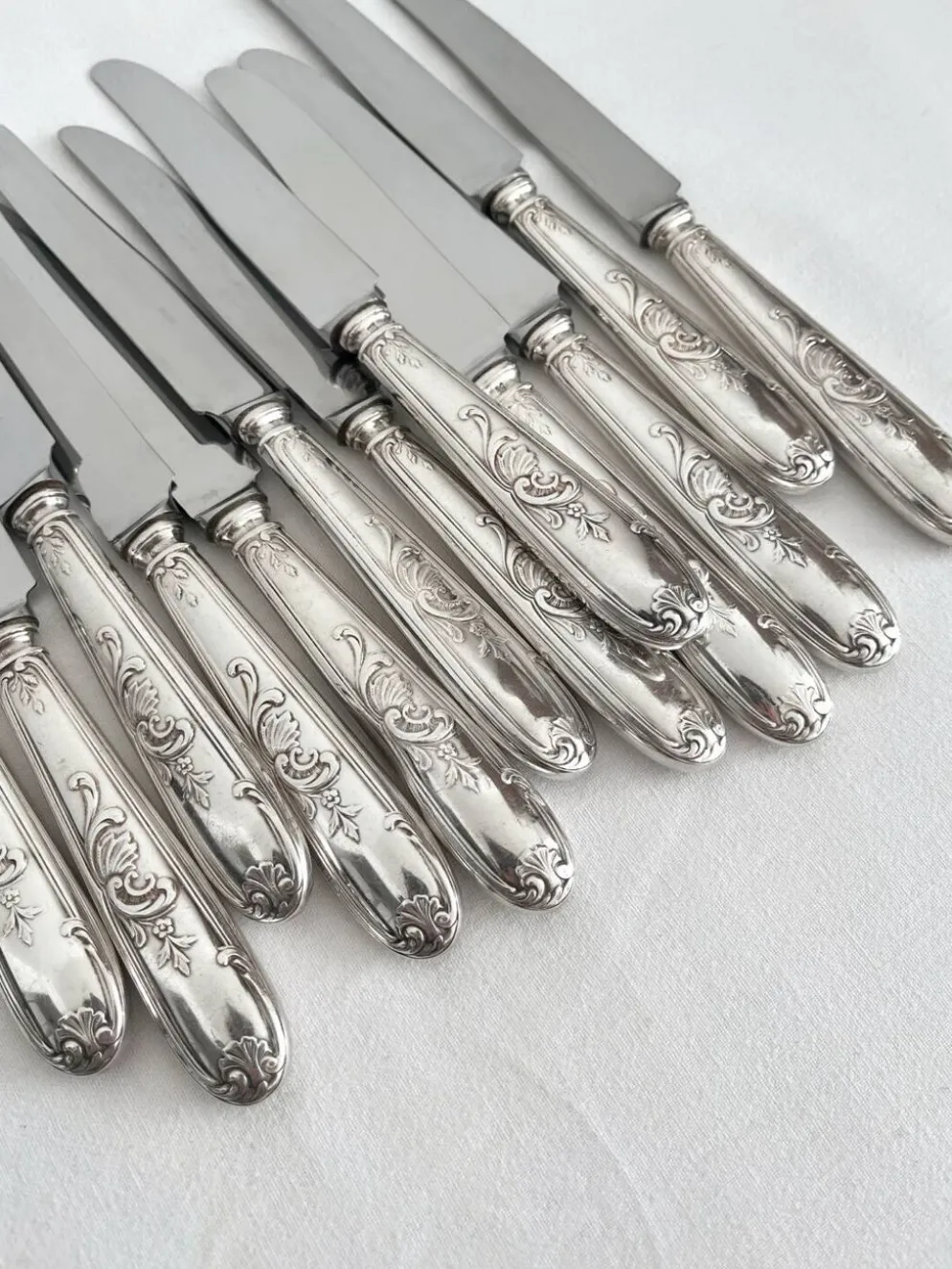 12 couteaux anciens en métal argenté décor acanthe coquille lame inox
