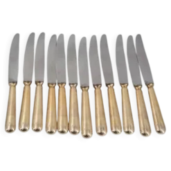 12 couteaux de table modèle Baguette, manches dorés, excellent état.
