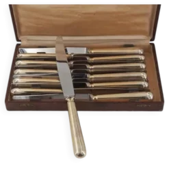 12 couteaux de table modèle Baguette, manches dorés, excellent état.