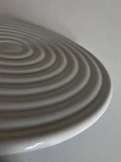 Dessous de plat de potier en terre vernissée blanche