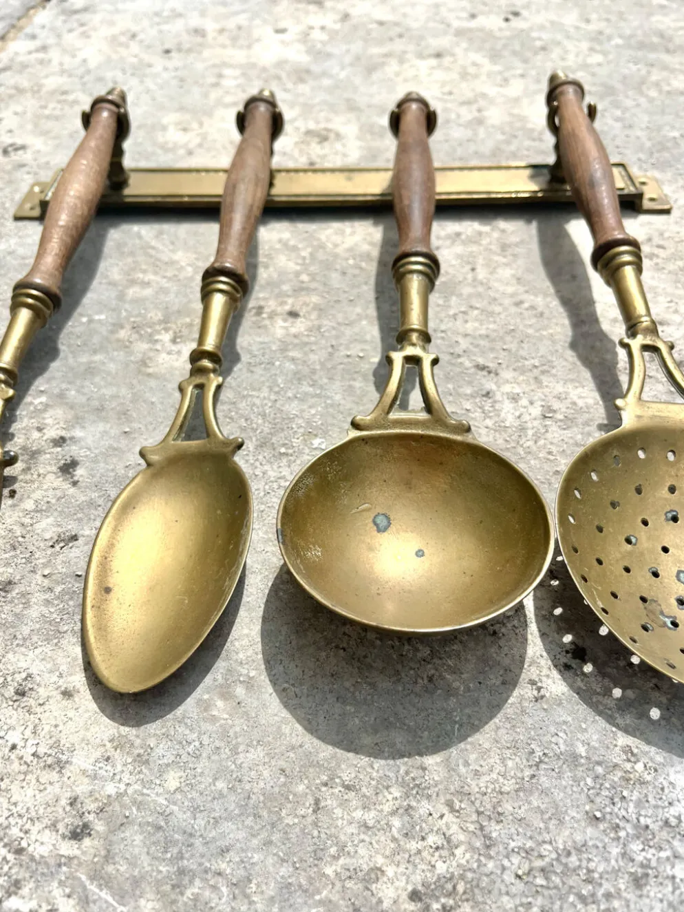 Ensemble d'ustensiles de cuisine en laiton, monté au mur avec des poignées en bois, vin français.
