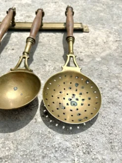 Ensemble d'ustensiles de cuisine en laiton, monté au mur avec des poignées en bois, vin français.