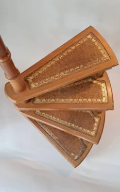 Escalier de bibliothèque en colimaçon en hêtre et cuir marron.