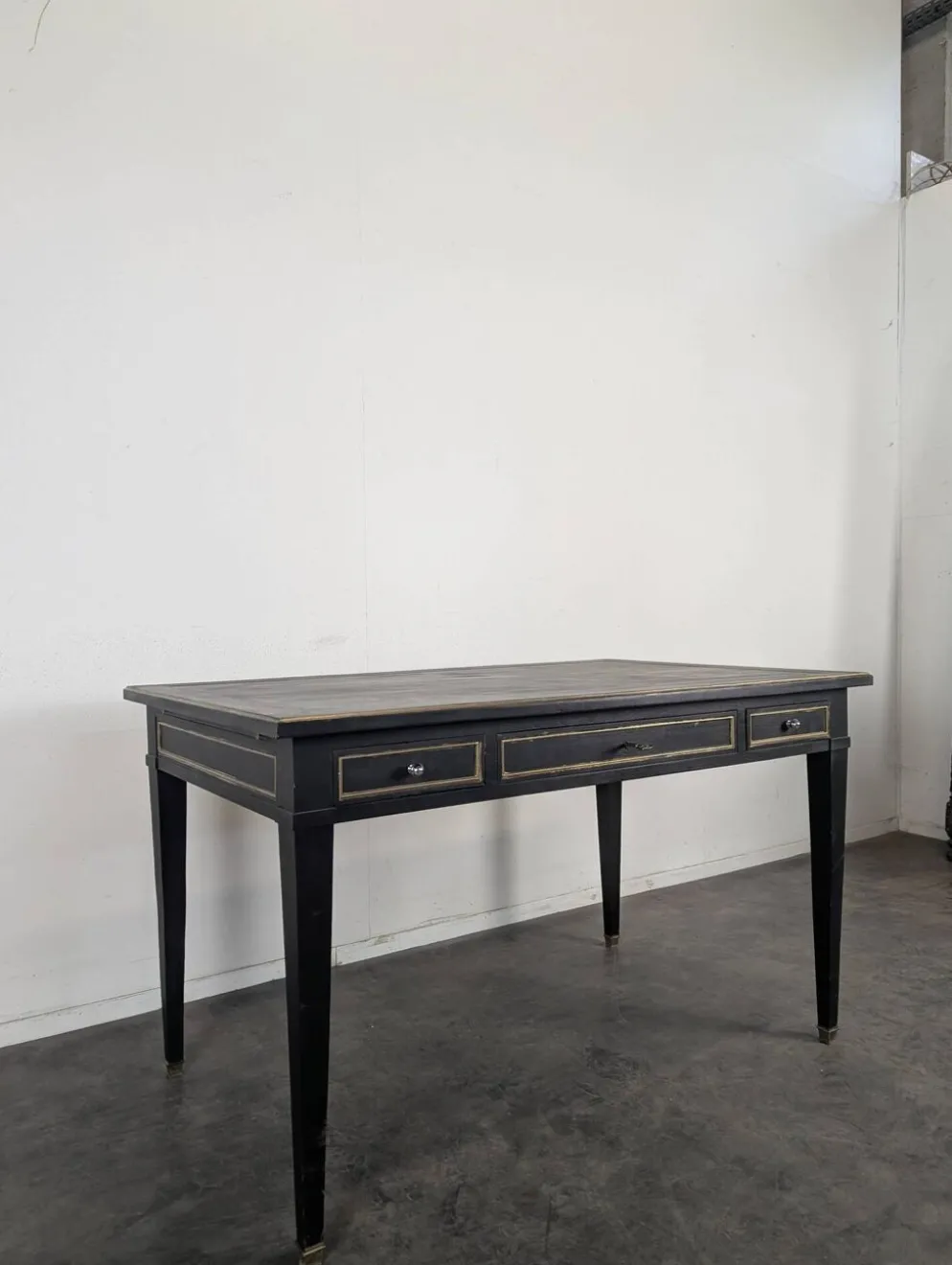 Grand bureau plat de style Louis XVI laqué noir et rechampi or