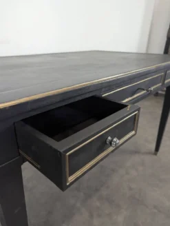 Grand bureau plat de style Louis XVI laqué noir et rechampi or