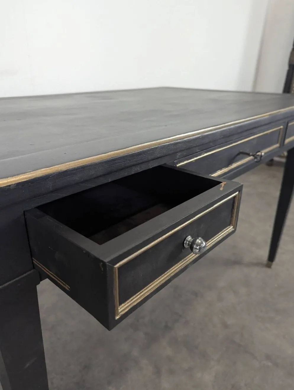 Grand bureau plat de style Louis XVI laqué noir et rechampi or