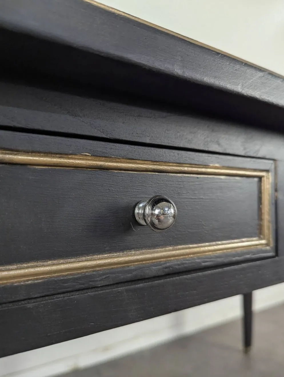 Grand bureau plat de style Louis XVI laqué noir et rechampi or