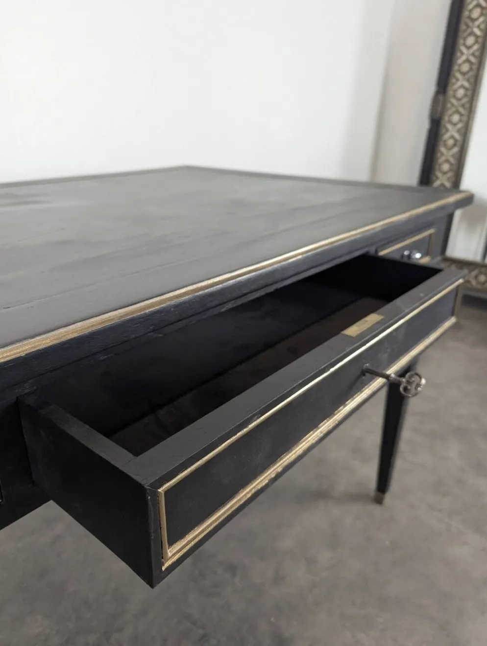 Grand bureau plat de style Louis XVI laqué noir et rechampi or
