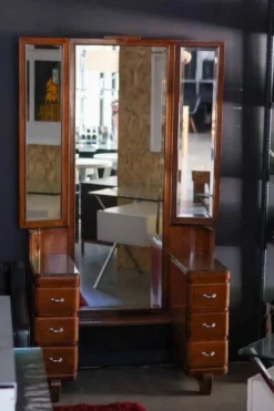 Hairdresser with a large shaped mirror and two pivoting side mirrors.