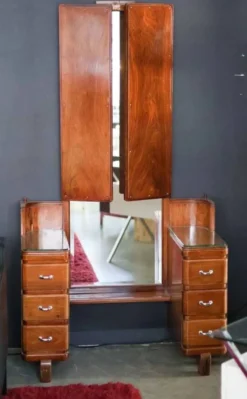 Hairdresser with a large shaped mirror and two pivoting side mirrors.