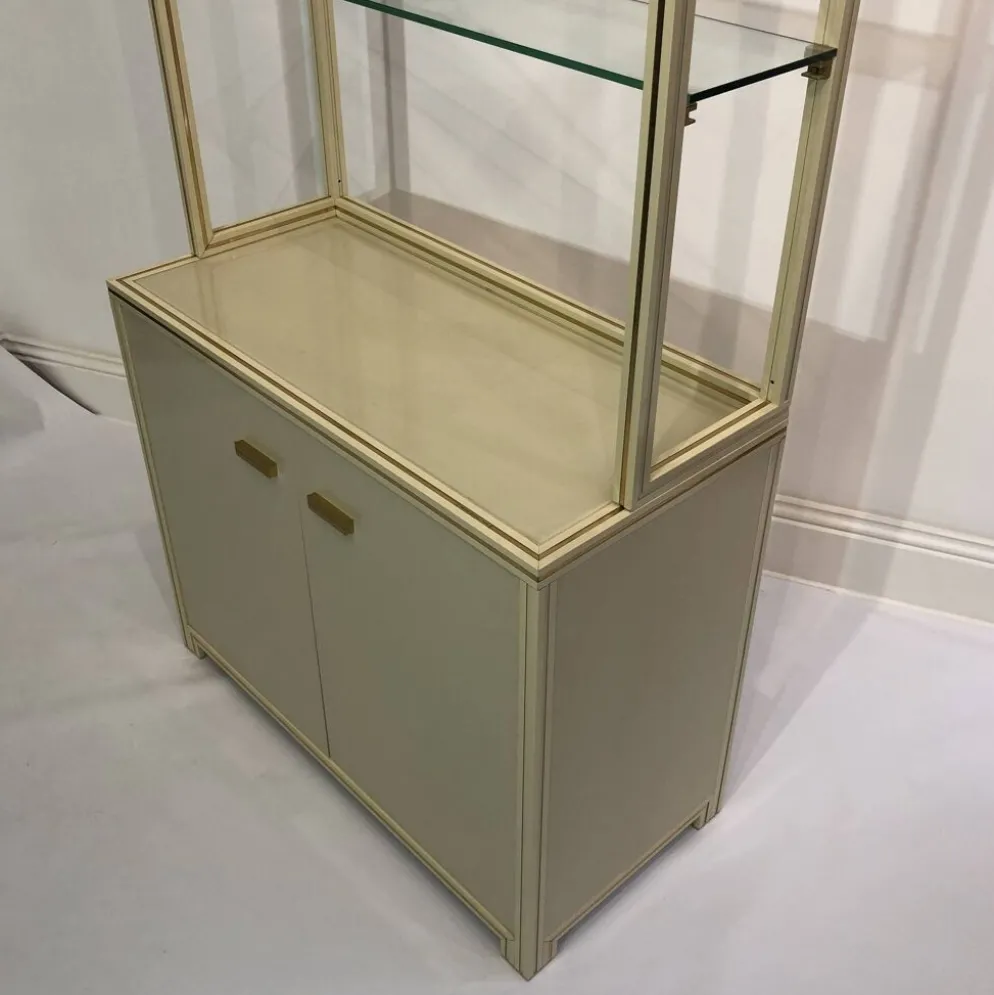 Paire d'armoires d'exposition Pierre Vandel des années 1970, étagères crème et laiton.